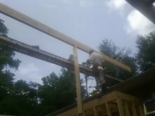 Carpenter setting a ridge beam over a new addition frame — Ice Dam Removal by Roofing Brothers in Jefferson